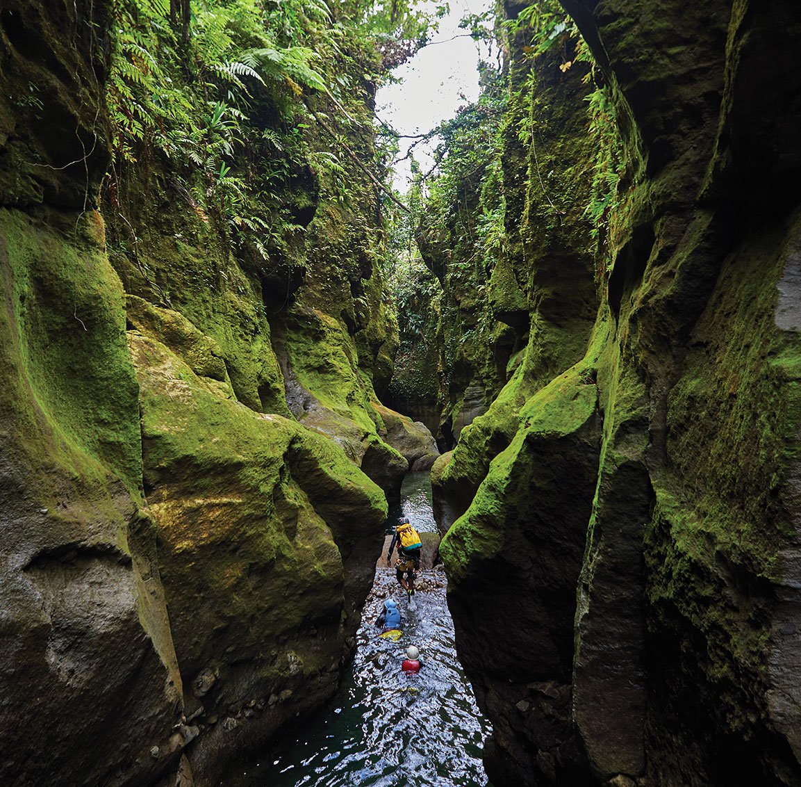 people traveling through a narrow canyon